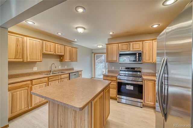 kitchen featuring appliances with stainless steel finishes, a center island, light hardwood / wood-style floors, sink, and light brown cabinetry