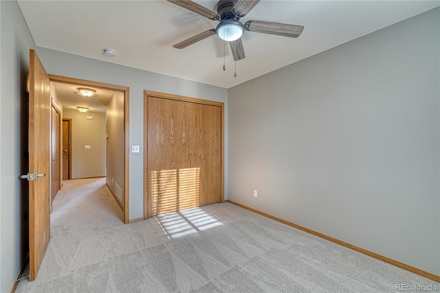 unfurnished bedroom with ceiling fan, light colored carpet, and a closet