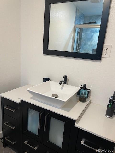 1473 S Monaco Pkwy S, Denver, CO 80224 - bathroom featuring vanity and a shower with shower door