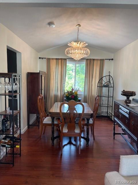 1473 S Monaco Pkwy S, Denver, CO 80224 - dining room featuring vaulted ceiling, a chandelier, wood finished floors, and baseboards