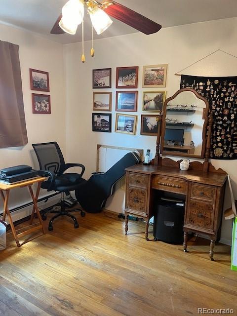 1473 S Monaco Pkwy S, Denver, CO 80224 - home office featuring wood finished floors, a ceiling fan, and baseboard heating