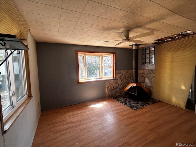 8319 Quivas Way, Denver, CO 80221 - unfurnished living room with wood finished floors, a wood stove, and a ceiling fan