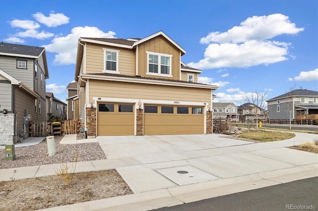 view of front of property featuring fence, stone siding, board and batten siding, concrete driveway, and an attached garage