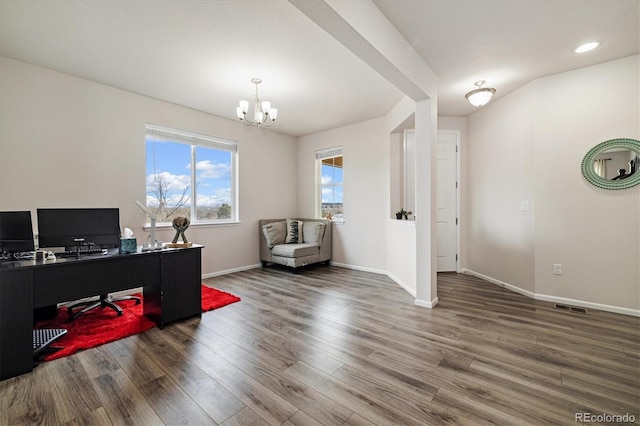 office area with an inviting chandelier, baseboards, wood finished floors, and visible vents