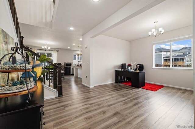 interior space featuring a chandelier, plenty of natural light, and wood finished floors