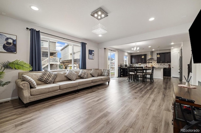 living area with recessed lighting, a healthy amount of sunlight, and wood finished floors