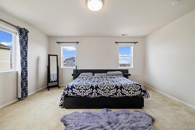 carpeted bedroom featuring baseboards and visible vents