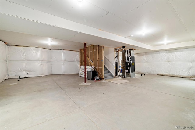 unfinished basement featuring heating unit and stairs