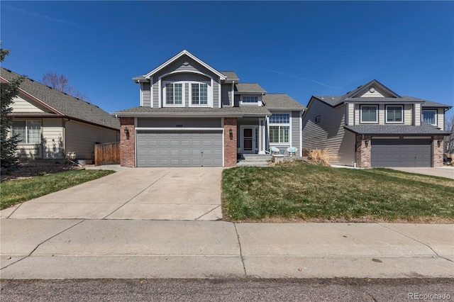 traditional-style home with a garage, concrete driveway, a front lawn, and brick siding