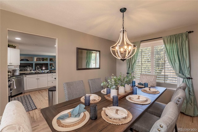 dining room featuring light wood finished floors and a chandelier