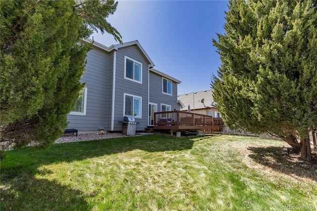 back of house featuring a deck and a lawn