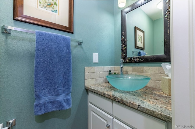 bathroom with a textured wall and vanity