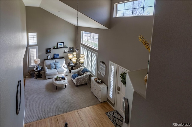 living room with high vaulted ceiling, plenty of natural light, and light wood-type flooring