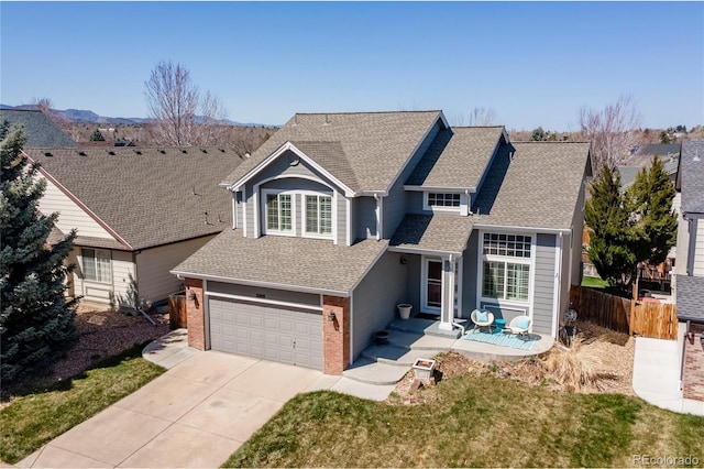 traditional home featuring fence, brick siding, an attached garage, a shingled roof, and concrete driveway