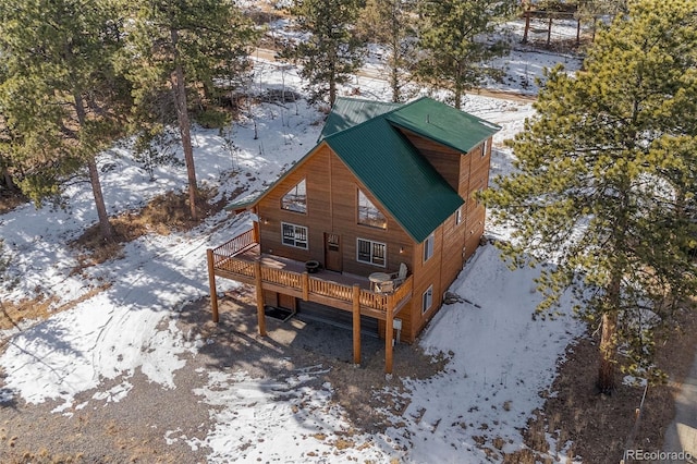 snow covered back of property featuring a deck