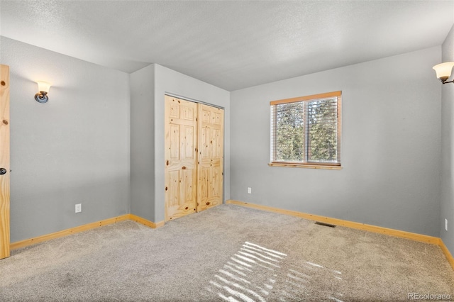 unfurnished bedroom featuring carpet and a textured ceiling