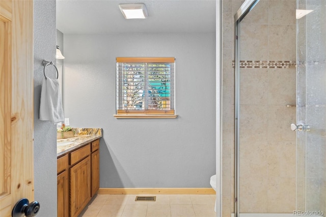 bathroom featuring tile patterned floors, vanity, toilet, and an enclosed shower