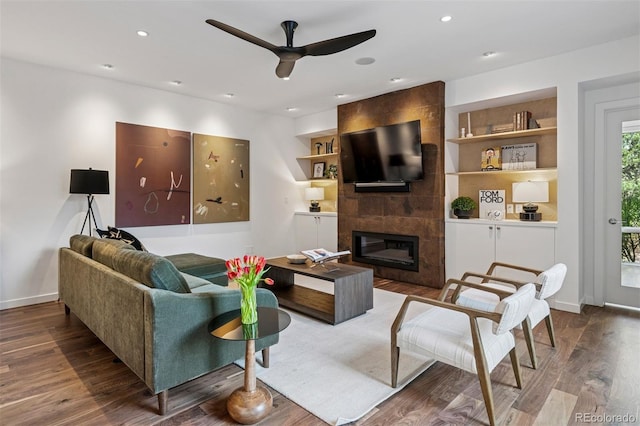 living area with recessed lighting, ceiling fan, wood finished floors, and a fireplace