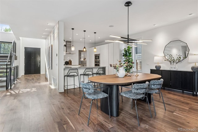 dining room with dark wood finished floors, a wealth of natural light, and stairway