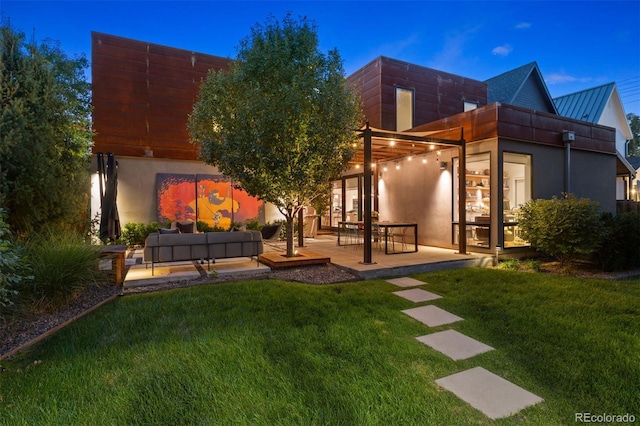 back of property featuring an outdoor hangout area, stucco siding, a lawn, and a patio area