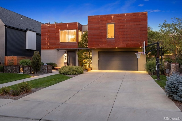 contemporary house with a garage, stucco siding, and concrete driveway