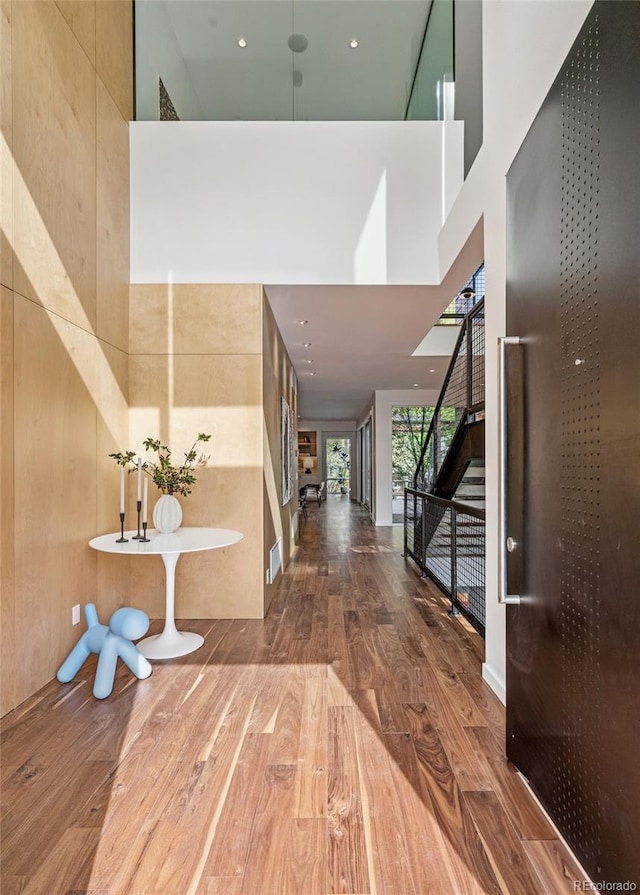 entryway featuring stairs, recessed lighting, a high ceiling, and wood finished floors