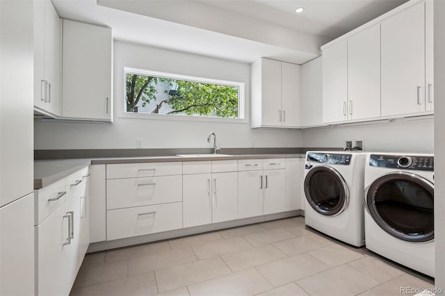laundry area with cabinet space, separate washer and dryer, recessed lighting, and a sink