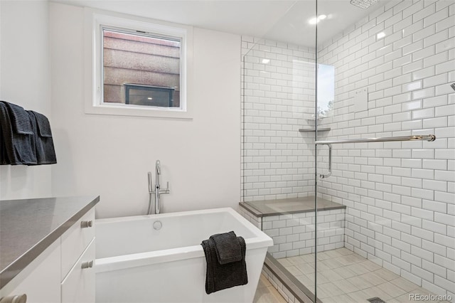 bathroom featuring vanity, a freestanding bath, and a stall shower