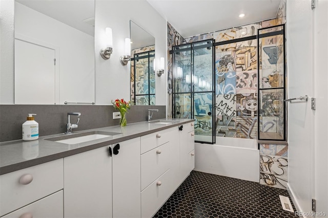 bathroom featuring double vanity, a shower with door, a freestanding bath, and a sink