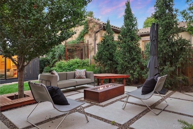 view of patio / terrace featuring fence and an outdoor living space with a fire pit