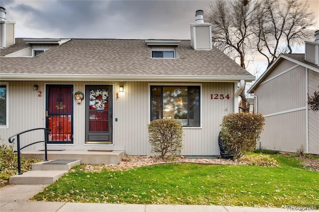1254 S Reed St Unit 1, Lakewood, CO 80232 - view of front of property featuring a front yard, a shingled roof, and a chimney