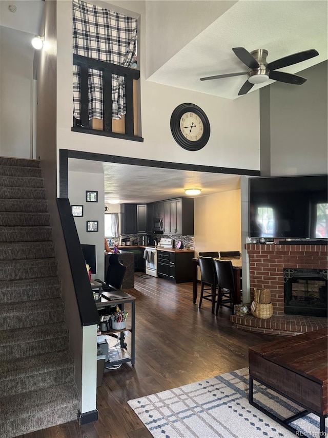 1254 S Reed St Unit 1, Lakewood, CO 80232 - living area featuring dark wood finished floors, stairs, ceiling fan, and a high ceiling