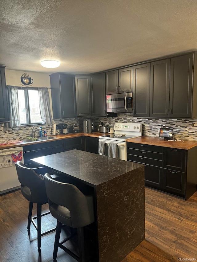 1254 S Reed St Unit 1, Lakewood, CO 80232 - kitchen featuring white appliances, tasteful backsplash, dark wood finished floors, a textured ceiling, and butcher block counters