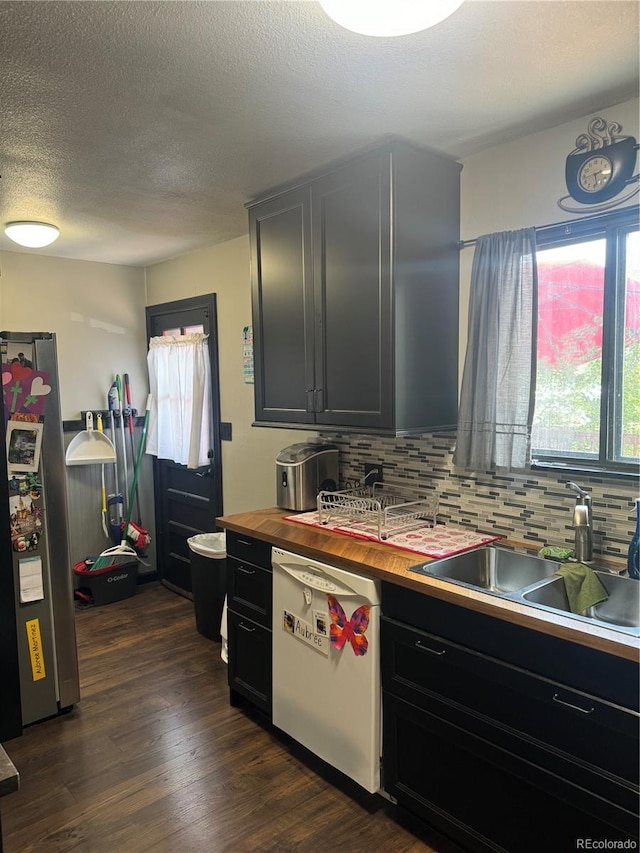 1254 S Reed St Unit 1, Lakewood, CO 80232 - kitchen with backsplash, white dishwasher, dark cabinetry, freestanding refrigerator, and dark wood finished floors