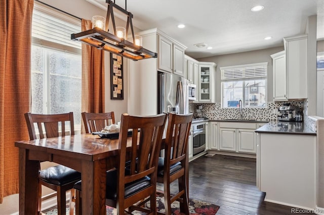 dining room featuring a notable chandelier, plenty of natural light, recessed lighting, and dark wood-type flooring