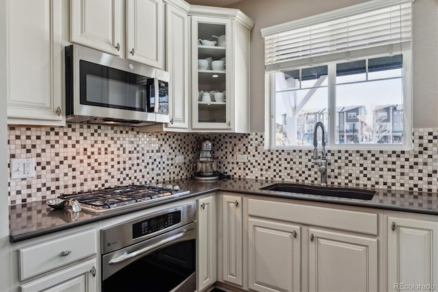 kitchen featuring dark countertops, appliances with stainless steel finishes, and a sink
