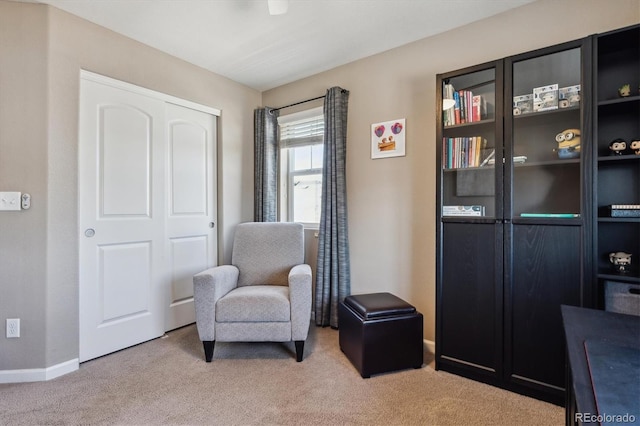 living area with baseboards and carpet