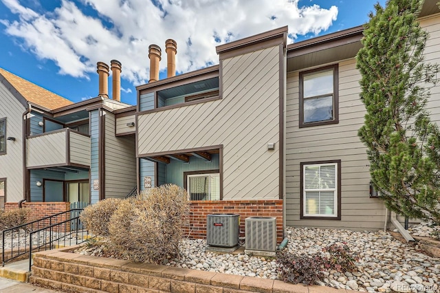 exterior space with central AC and brick siding