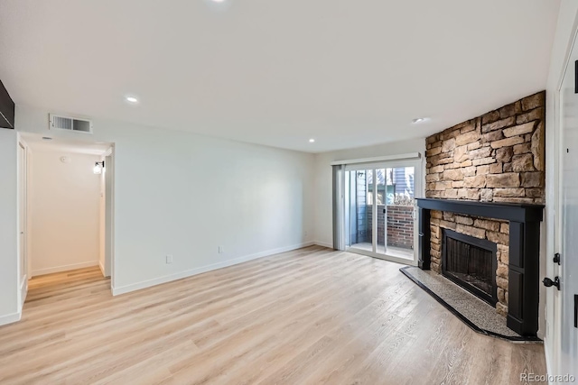 unfurnished living room with baseboards, visible vents, light wood-type flooring, a fireplace, and recessed lighting