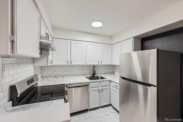 kitchen featuring marble finish floor, appliances with stainless steel finishes, white cabinets, a sink, and light stone countertops