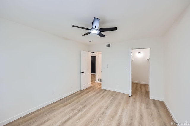 unfurnished bedroom with baseboards, visible vents, a ceiling fan, light wood-style flooring, and a spacious closet