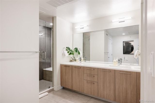 bathroom with vanity, a shower with shower door, and tile patterned floors