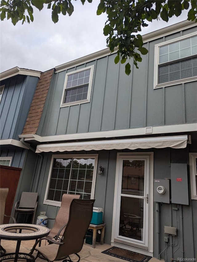 9060 E Cherry Creek S Drive E, Denver, CO 80231 - rear view of house with board and batten siding and a patio