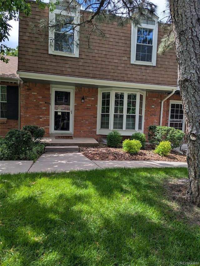 9060 E Cherry Creek S Drive E, Denver, CO 80231 - view of front of home featuring a front lawn, a shingled roof, and brick siding