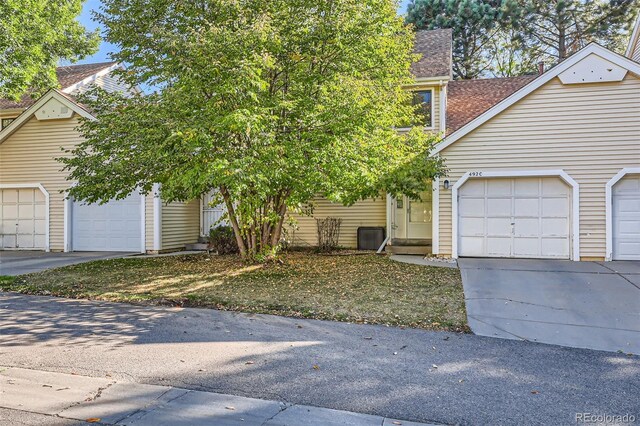 view of front facade featuring concrete driveway and a shingled roof
