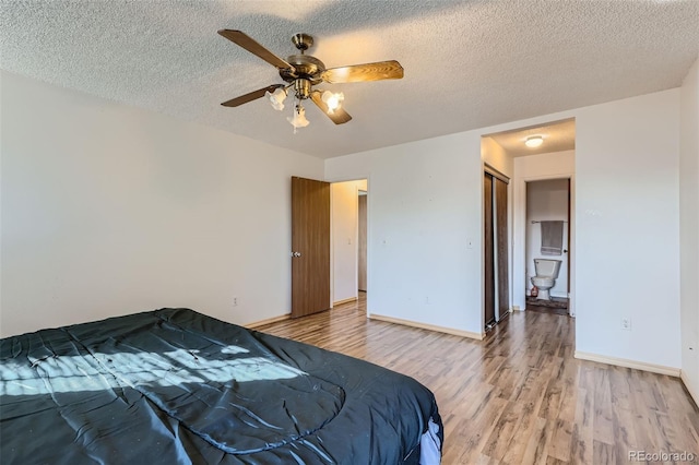 bedroom with light wood finished floors, baseboards, a textured ceiling, and a ceiling fan