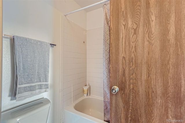 bathroom with toilet and shower / bath combo with shower curtain