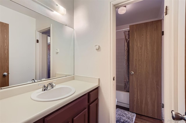 bathroom with shower / bathtub combination with curtain, vanity, and wood finished floors