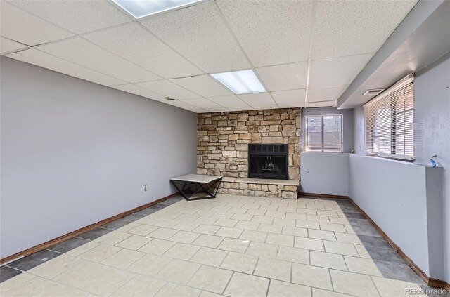 unfurnished living room featuring visible vents, baseboards, a drop ceiling, and a fireplace