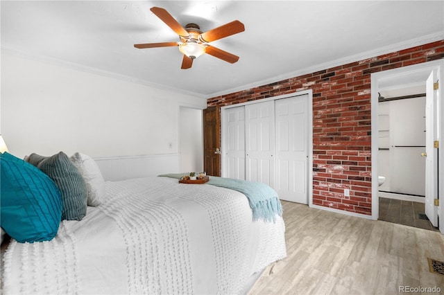 16308 E Wyoming Dr, Aurora, CO 80017 - bedroom featuring ornamental molding, wood finished floors, a closet, brick wall, and ceiling fan